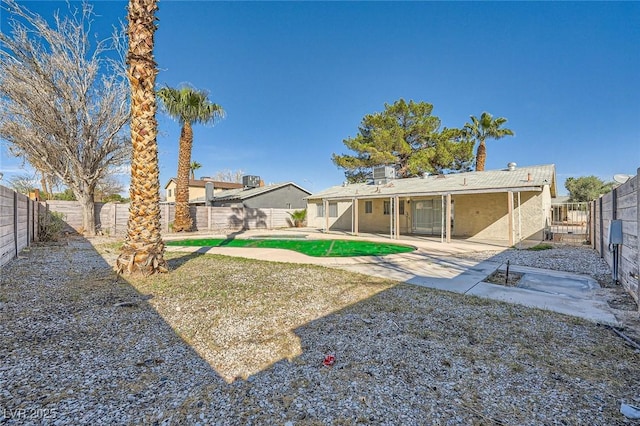 rear view of property with stucco siding, a patio, and a fenced backyard