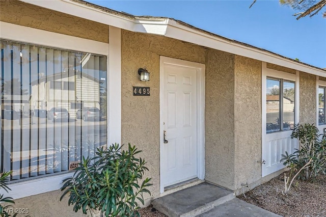 doorway to property featuring stucco siding