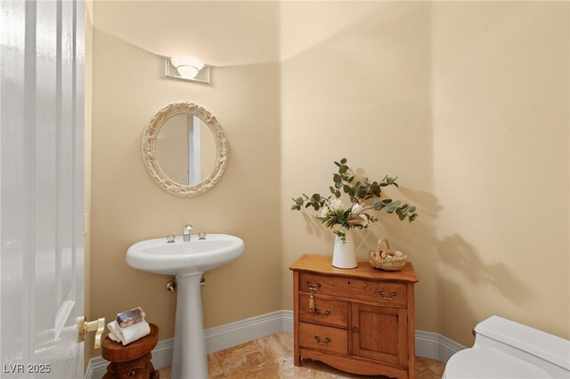 bathroom with toilet and baseboards