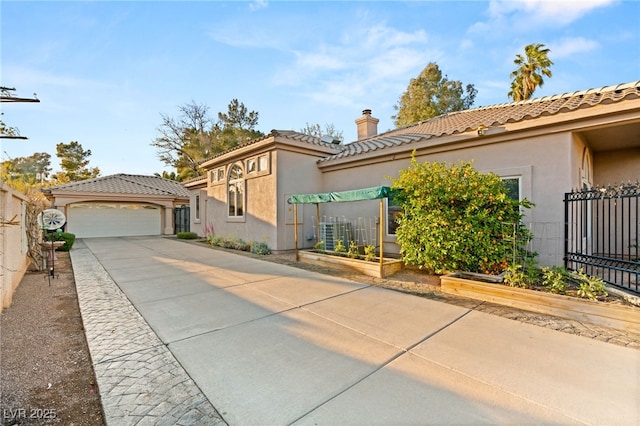 mediterranean / spanish-style home featuring fence, a tile roof, stucco siding, a chimney, and a garden