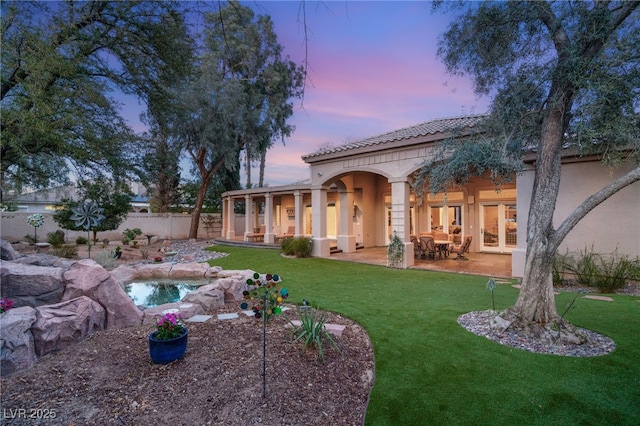 back of property featuring fence, an in ground hot tub, a yard, stucco siding, and a patio area