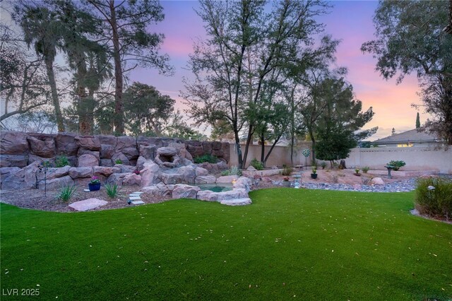 yard at dusk featuring fence