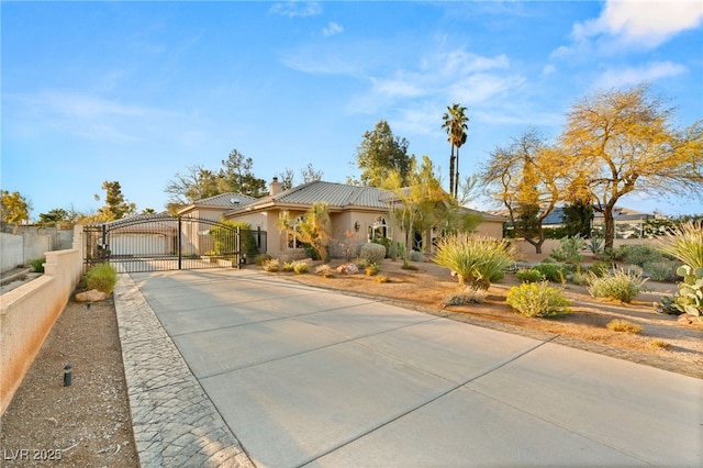 view of front of house featuring stucco siding, fence, a chimney, and a gate