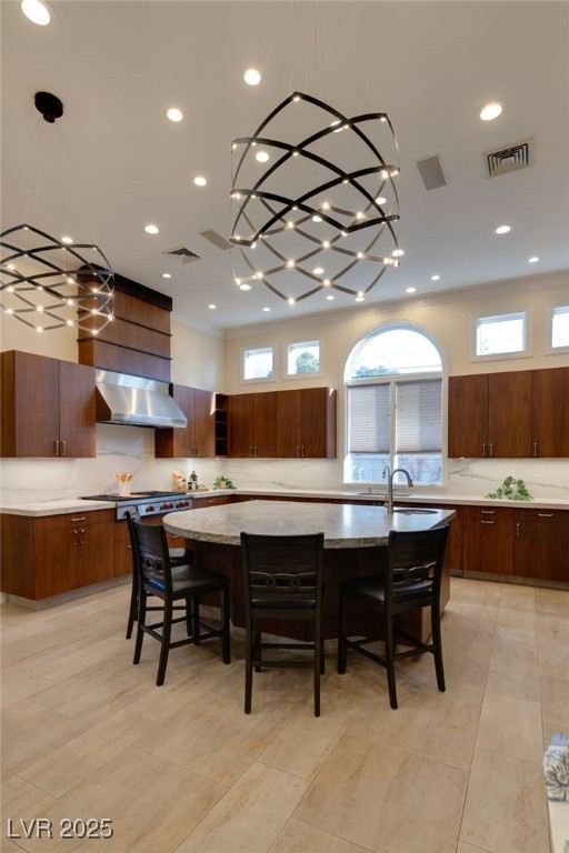 kitchen with visible vents, modern cabinets, a breakfast bar, a spacious island, and extractor fan