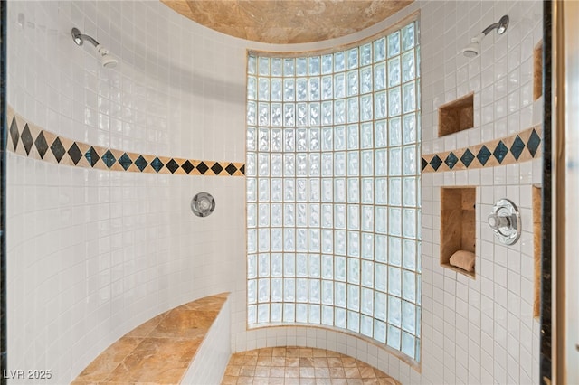 bathroom featuring a wealth of natural light and tiled shower