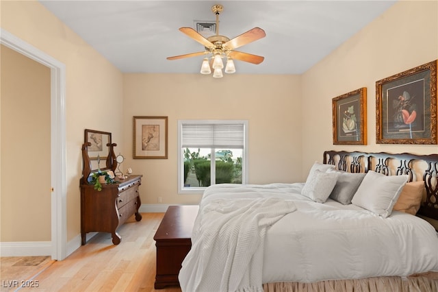 bedroom featuring visible vents, baseboards, ceiling fan, and light wood finished floors