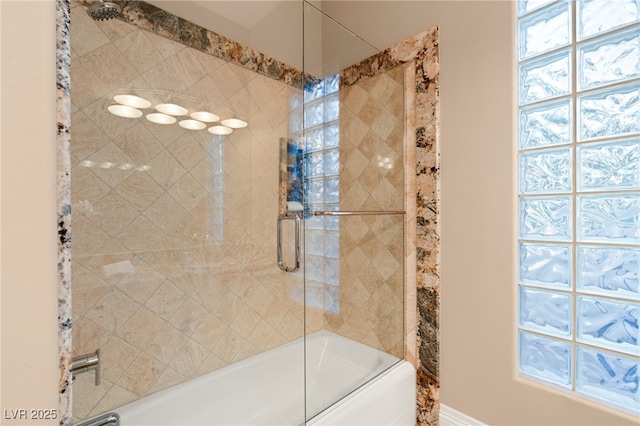 bathroom featuring bath / shower combo with glass door