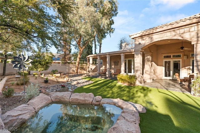 view of yard featuring french doors, a patio, a ceiling fan, and fence