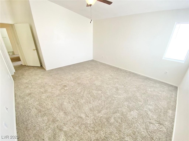 carpeted spare room featuring a ceiling fan