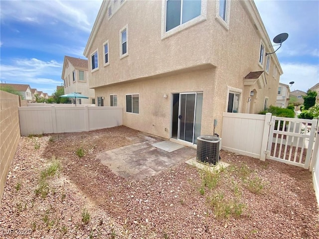 back of house featuring a patio area, central air condition unit, stucco siding, and a fenced backyard