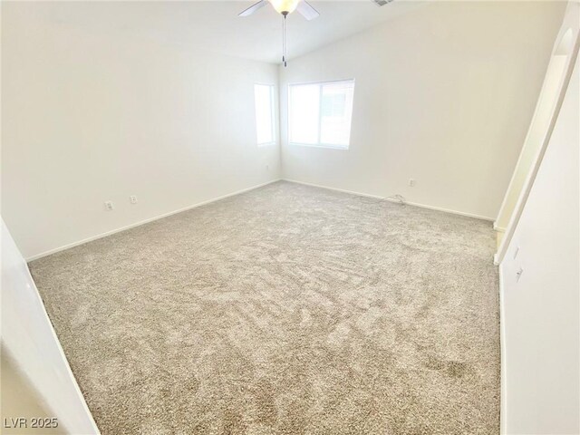 spare room featuring baseboards, carpet, lofted ceiling, and ceiling fan