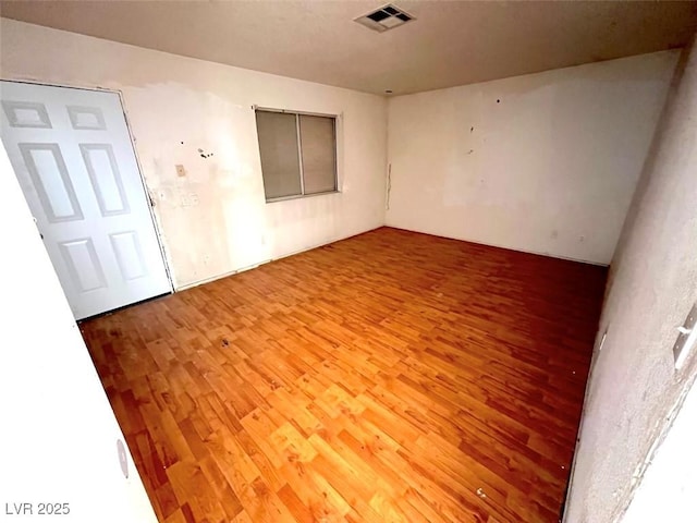 spare room with visible vents and wood finished floors