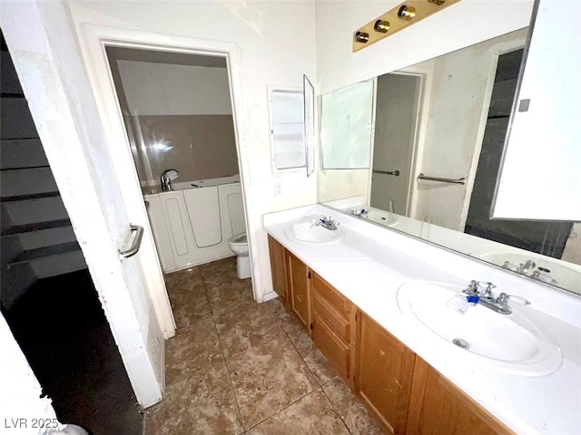 bathroom featuring double vanity, tile patterned flooring, toilet, and a sink