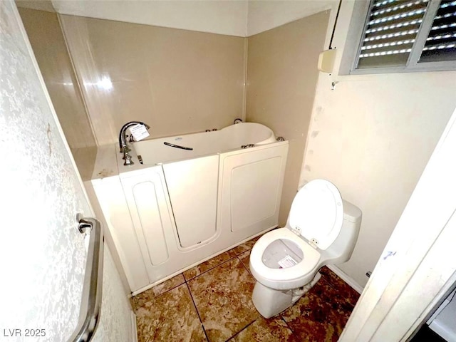 bathroom with tile patterned floors, toilet, and a tub