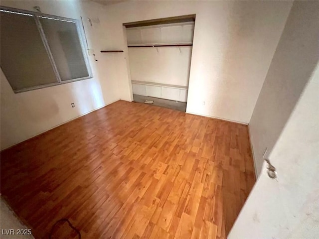 unfurnished bedroom with a closet and wood finished floors