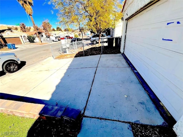 exterior space with a residential view, driveway, and a gated entry