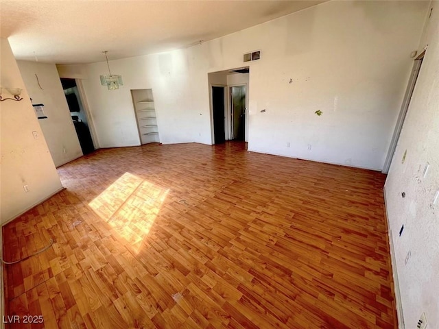 empty room with wood finished floors and visible vents