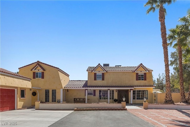 view of front of home featuring fence, stucco siding, concrete driveway, a garage, and a tiled roof