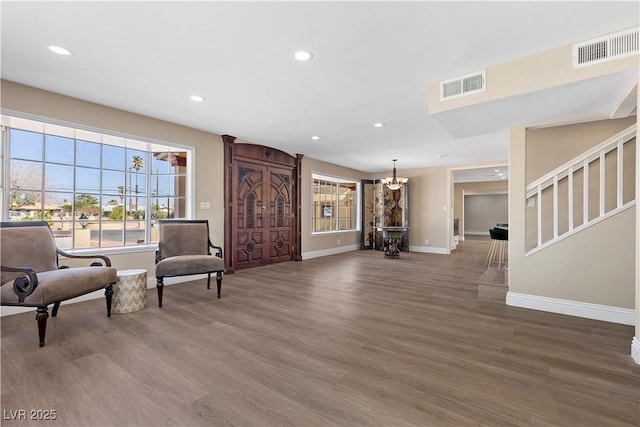 sitting room with visible vents, wood finished floors, and stairs