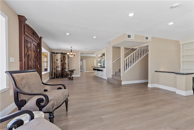 living area with visible vents, recessed lighting, stairway, light wood finished floors, and baseboards