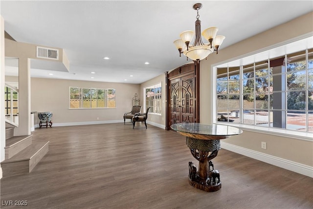 interior space with wood finished floors, visible vents, and baseboards