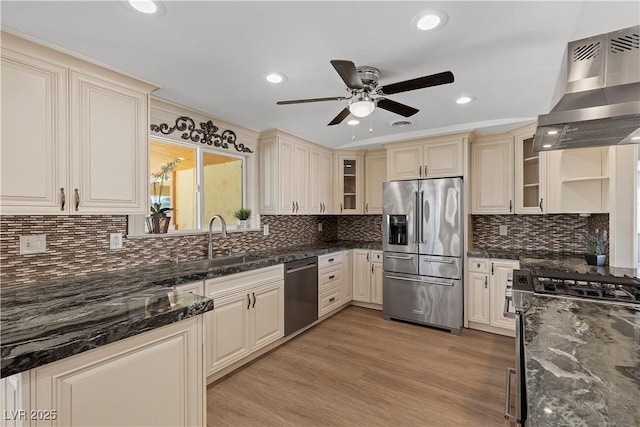 kitchen featuring a sink, stainless steel appliances, cream cabinets, and range hood