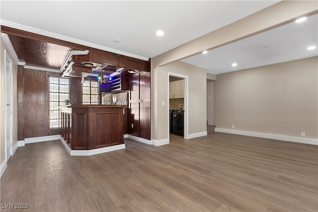 interior space featuring wood finished floors, recessed lighting, a bar, separate washer and dryer, and baseboards