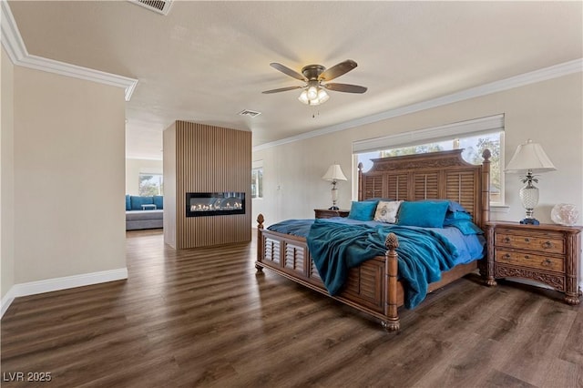 bedroom featuring baseboards, a fireplace, wood finished floors, and crown molding