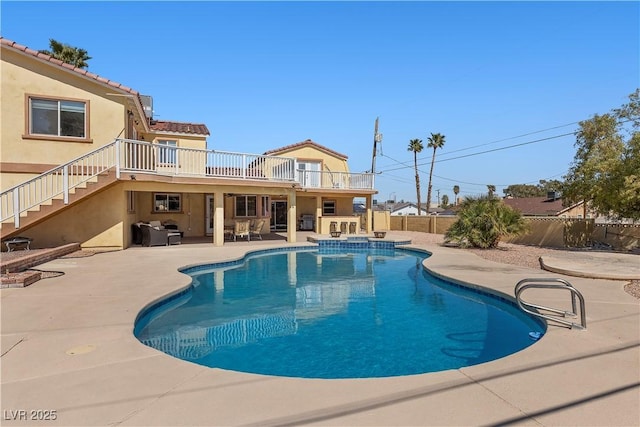 view of swimming pool with a patio area, a pool with connected hot tub, stairs, and a fenced backyard