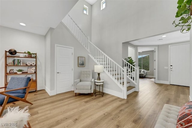 interior space featuring recessed lighting, stairway, baseboards, and wood finished floors