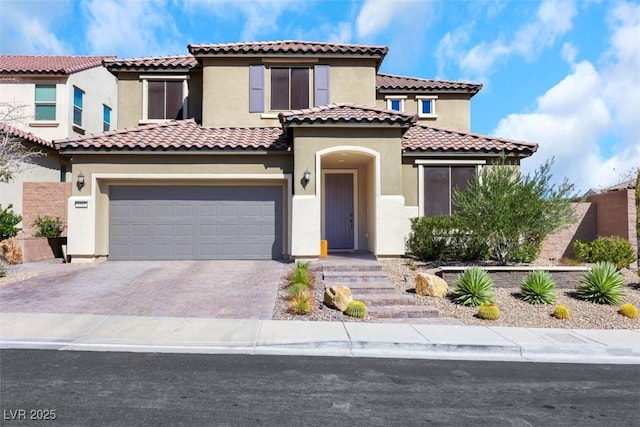 mediterranean / spanish-style home featuring stucco siding, driveway, and a garage