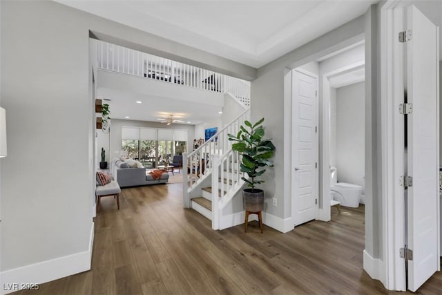 foyer with recessed lighting, baseboards, wood finished floors, and stairs