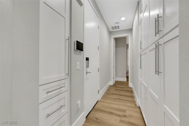 hallway with recessed lighting, baseboards, visible vents, and light wood-type flooring