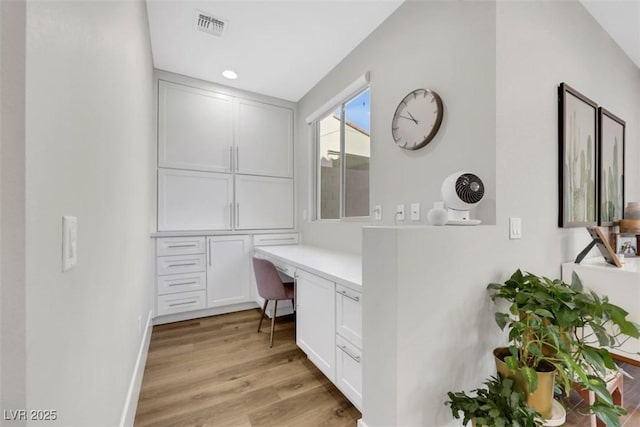 home office with visible vents, baseboards, built in desk, recessed lighting, and light wood-style floors