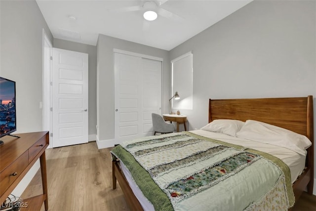 bedroom featuring a closet, baseboards, ceiling fan, and wood finished floors