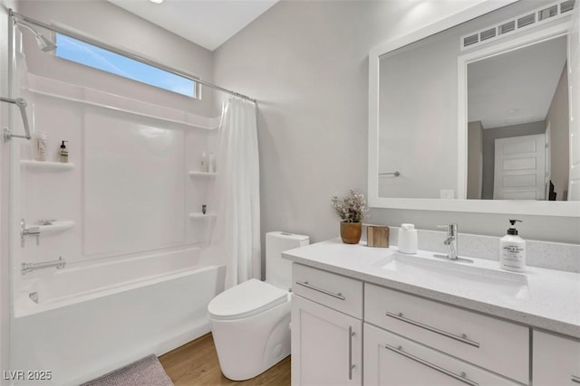 bathroom featuring visible vents, toilet, shower / tub combo, wood finished floors, and vanity