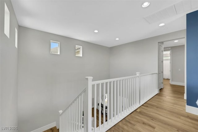 hall with visible vents, baseboards, an upstairs landing, recessed lighting, and wood finished floors