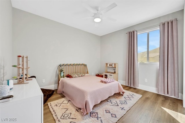 bedroom featuring ceiling fan, baseboards, and light wood-style flooring