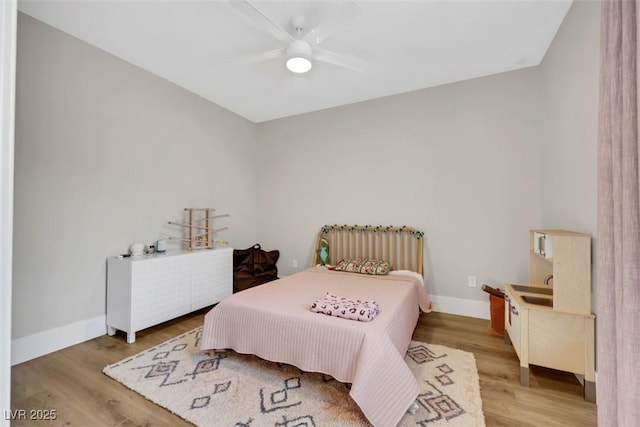 bedroom featuring a ceiling fan, baseboards, and light wood finished floors