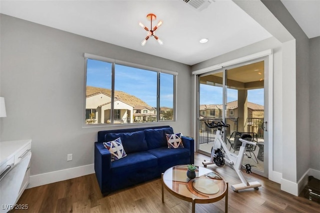 living room with visible vents, baseboards, and wood finished floors