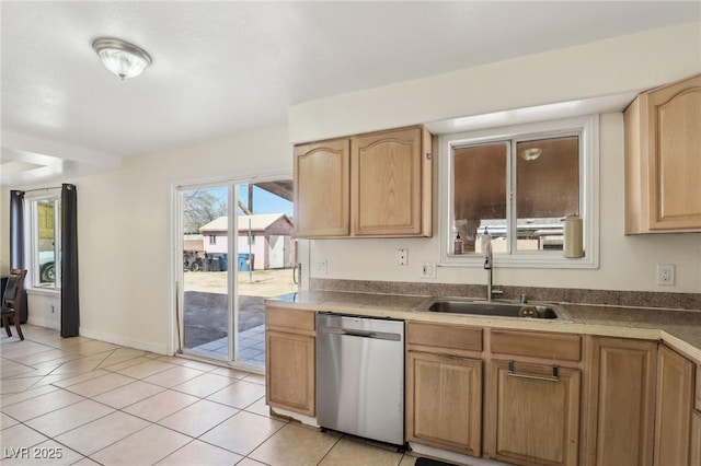 kitchen with a sink, baseboards, stainless steel dishwasher, and light tile patterned flooring