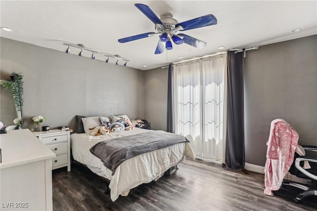 bedroom with dark wood finished floors, track lighting, and ceiling fan