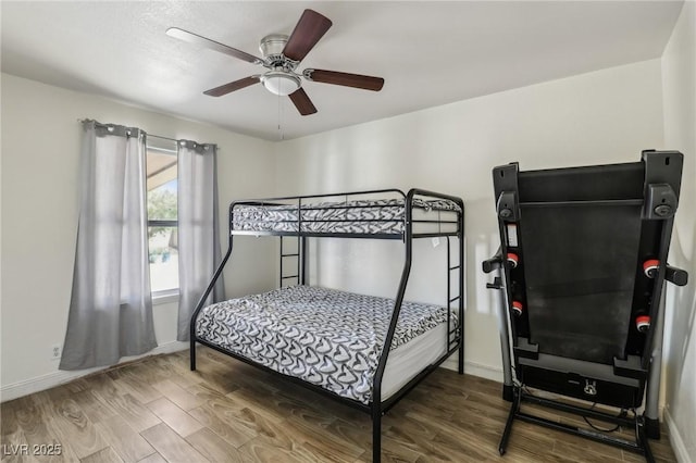 bedroom featuring a ceiling fan, baseboards, and wood finished floors