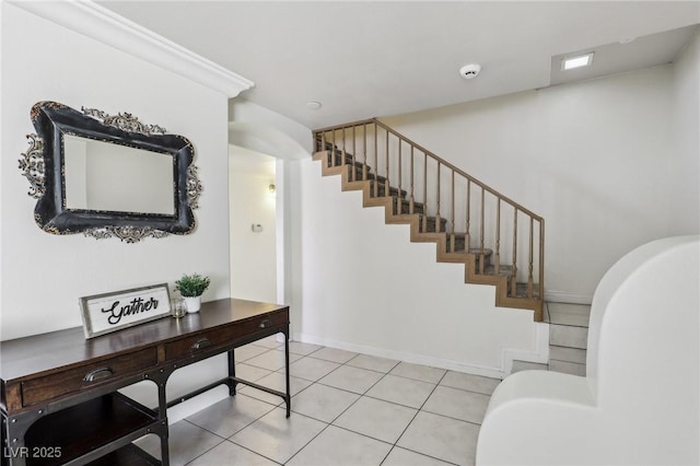 entryway with light tile patterned floors, stairway, and baseboards