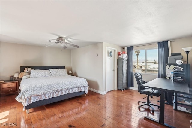 bedroom featuring baseboards, wood-type flooring, and a ceiling fan