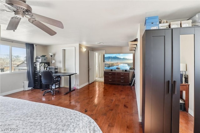 bedroom with hardwood / wood-style flooring, a ceiling fan, and baseboards