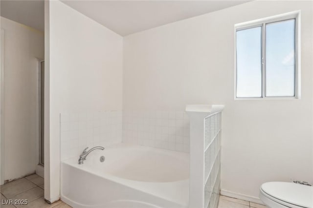 full bath with tile patterned flooring, toilet, a bath, and baseboards