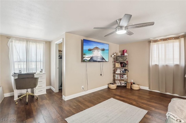 interior space featuring a ceiling fan, baseboards, and hardwood / wood-style floors