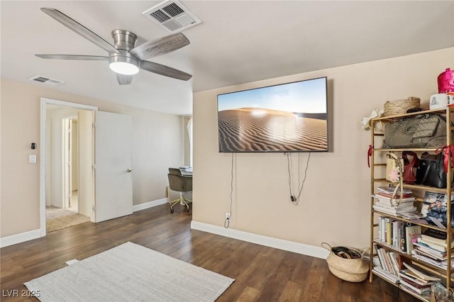 living area with visible vents, baseboards, and wood finished floors