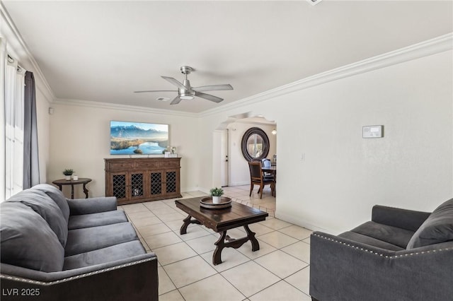 living area featuring crown molding, light tile patterned floors, a ceiling fan, and arched walkways